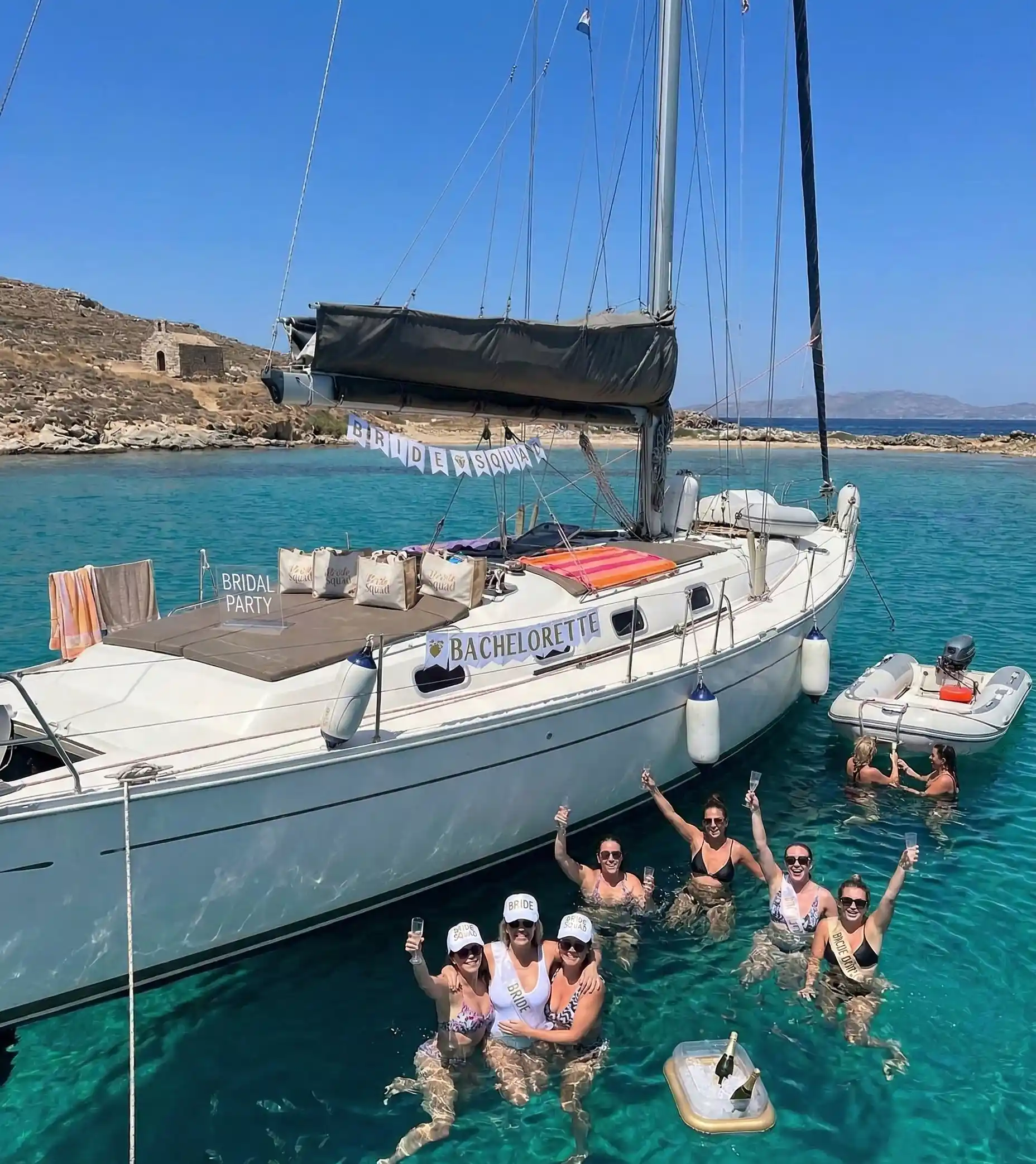 A group of friends enjoying swimming at a beautiful coastline in Rhenia Island, Greece, in the background.
