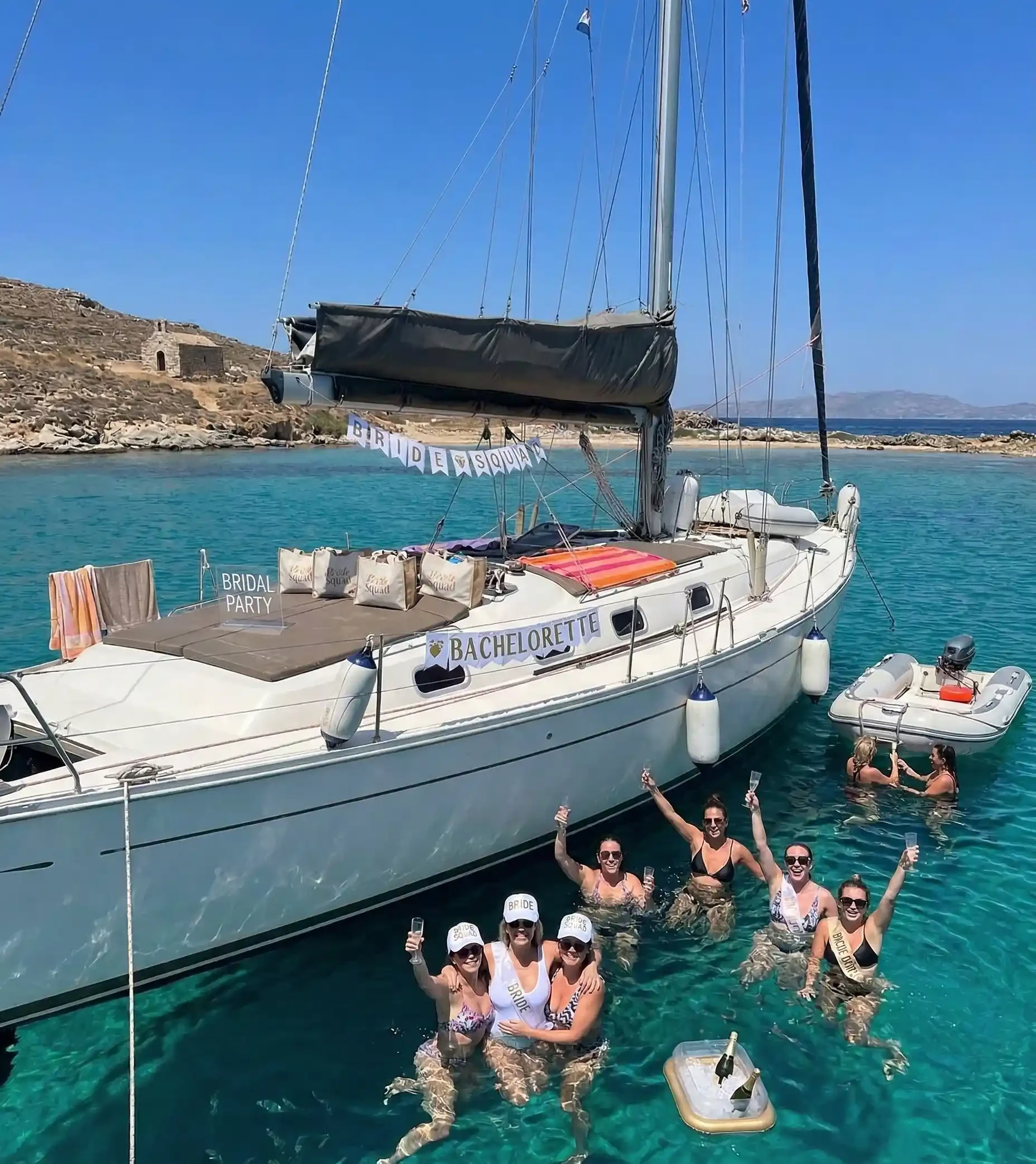 A group of friends enjoying swimming at a beautiful coastline in Rhenia Island, Greece, in the background.
